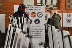 Presenter and visitor discussing a military history display