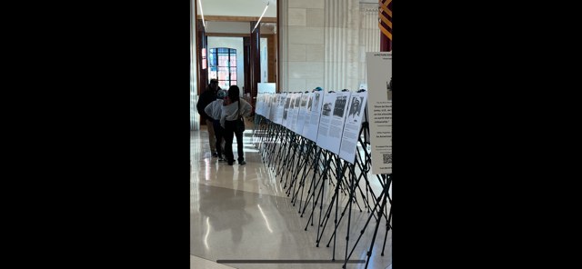 Rows of picture exhibits on easels in a public hall