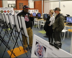 Museum presenter explaining an exhibit to visitors
